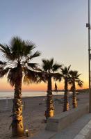 een rij palmbomen op een strand bij zonsondergang bij Villa Salisà in Menfi