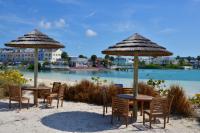 twee tafels en stoelen met parasols op een strand bij Sandyport Beach Resort in Nassau