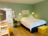 a bedroom with a white bed and a green wall at Studio Fresh&amp;Cosy Trois-Ilets - 3 étoiles-Hotel Carayou in Les Trois-Îlets
