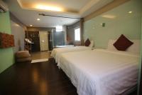 a hotel room with two beds and a bathroom at Kenting Waterfront Hotel in Kenting