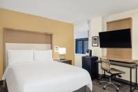 a hotel room with a bed and a desk and a television at Holiday Inn Toronto Downtown Centre by IHG in Toronto
