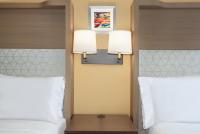 a bedroom with two beds and two lamps on the wall at Holiday Inn Toronto Downtown Centre by IHG in Toronto