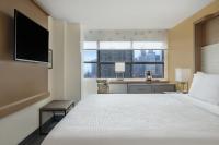 a hotel room with a bed and a desk with a window at Holiday Inn Toronto Downtown Centre by IHG in Toronto
