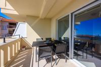 a balcony with a black table and chairs on it at Apartments Petak Novi in Dramalj