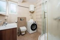 a bathroom with a washing machine next to a toilet at Apartments Petak Novi in Dramalj