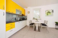 a kitchen with yellow cabinets and a table and chairs at Apartments Petak Novi in Dramalj