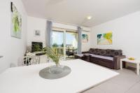 a living room with a white table and a couch at Apartments Petak Novi in Dramalj