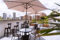 a row of tables and chairs with umbrellas on a balcony at Tuki Hostel & Lounge in Pereira