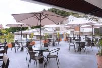 an outdoor patio with tables and chairs and umbrellas at Tuki Hostel & Lounge in Pereira