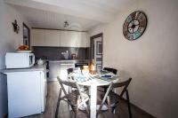 a kitchen with a table with chairs and a clock on the wall at Appartement d&#39;une chambre avec vue sur la ville et wifi a Embrun in Embrun