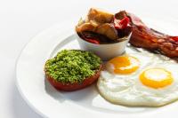 a white plate with an egg and bacon and a muffin at The Ritz-Carlton, Sarasota in Sarasota