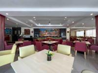 een restaurant met tafels en stoelen en paarse stoelen bij Hotel Seri Costa in Melaka