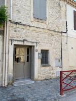 a stone building with a door and a red bench at Bienvenue au 6 - Calme et charme de la pierre. in Fourques