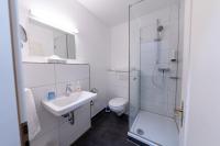 a white bathroom with a sink and a toilet at Hotel Bergbauer in Neuburg an der Donau