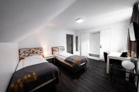 a hotel room with two beds and a desk at Hotel Bergbauer in Neuburg an der Donau
