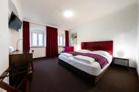 a hotel room with a large bed and a desk at Hotel Bergbauer in Neuburg an der Donau