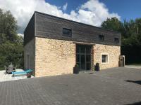 a brick building with a blue bench in front of it at Grange rénovée esprit loft Côte d&#39;Opale in Wierre-Effroy