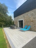 a patio with blue chairs and a building at Grange rénovée esprit loft Côte d&#39;Opale in Wierre-Effroy