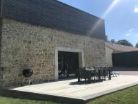 a stone building with a patio with chairs and a grill at Grange rénovée esprit loft Côte d&#39;Opale in Wierre-Effroy