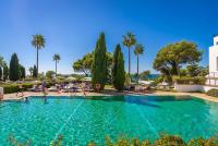 a swimming pool at a resort with palm trees at Hotel Fuerte Conil-Resort in Conil de la Frontera