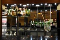 Una copa de martini con una lima y una pajita en la barra en Hotel Orion Centrally near North Goa & Panjim, en Porvorim