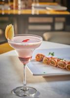 Una copa de martini con una rodaja de limón sobre una mesa. en Hotel Orion Centrally near North Goa & Panjim, en Porvorim