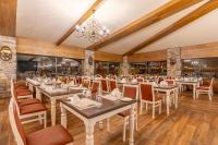 a dining room with tables and chairs and a chandelier at Mirada Del Lago in Erciyes