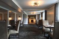 een eetkamer met tafels en stoelen en een plafond bij Equinox Resort Residences in Manchester