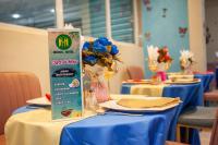 Una mesa con mantel azul y un cartel encima. en HOTEL MICKEL, en Douala