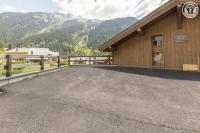 a parking lot in front of a building with mountains at Chalet Bio Corti 6p. 3 ch proche pistes&#47;commerces in Champagny-en-Vanoise