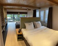 a bedroom with a large bed and a living room at B&amp;B - Ter Douve in Dranouter