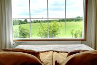 a bed in a room with a large window at Tertin Kartano in Mikkeli