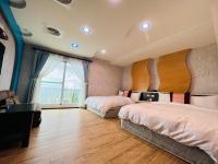a bedroom with two beds and a large window at Ibizakenting Hotel in Kenting