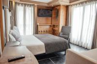 a hotel room with a bed and a chair at Hôtel Alpina &amp; SPA in Les Gets