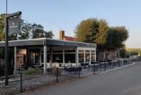 a restaurant with tables and chairs on the side of the road at Waterlodge in Wilhelminadorp