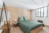 Un dormitorio con una cama verde y una ventana en Charmant &amp; spacieux appartement en cœur de ville, en Saint-Étienne