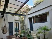 a house with a patio with plants and a window at Loft en duplex 270 m2 &amp; Jardin patio terrasse sauna in Chaville