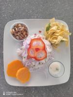 a white plate of food with vegetables and nuts at Las Fragatas Casa Hotel in Canoas De Punta Sal