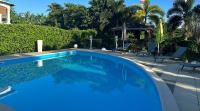 a swimming pool with blue water in a yard at Appartement Coeur de Papillon in Baie-Mahault