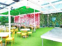 un ristorante con tavoli e sedie e una parete di piante di Genting RetreatColdSuite AT Ion Delemen a Resorts World Genting