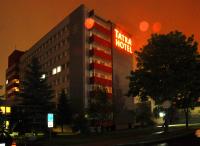 a hotel building with a sign on it at night at Tatra Hotel in Poprad