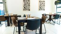 un comedor con mesas y sillas con vasos encima. en Windhoek Gardens Boutique Hotel, en Windhoek