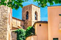 a building with a tower with a clock on it at Mobile home 5-pers Camping Leï Suves-Côtes d&#39;Azur-including airco in Roquebrune-sur-Argens