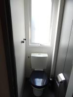 a bathroom with a blue toilet with a window at Mobile home 5-pers Camping Leï Suves-Côtes d&#39;Azur-including airco in Roquebrune-sur-Argens