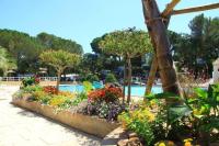 a garden in front of a swimming pool with flowers at Mobile home 5-pers Camping Leï Suves-Côtes d&#39;Azur-including airco in Roquebrune-sur-Argens