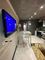 a kitchen with a table and a tv on a wall at LA MARIEFACTURE - Comme c&#39;est chic in Saint-Avold