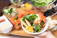 a person holding a bowl of salad and fries at APA Hotel TKP Nippori Ekimae in Tokyo