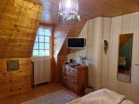 a bedroom with a bed and a tv in a wooden ceiling at L&#39;Etang de la Gourdinière in Landisacq