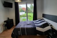 Un dormitorio con una cama y una ventana grande. en Studio avec piscine près d&#39;Honfleur, en Équemauville