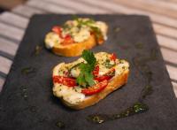 Dos rebanadas de pan con tomate y queso en un plato. en Pauli Boutique Hotel, en Fortaleza